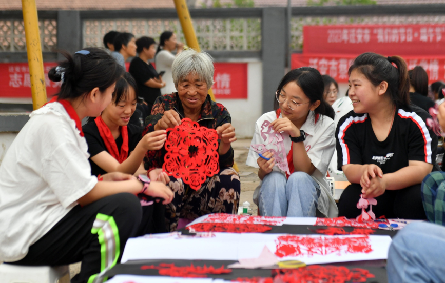 6月19日，在迁安市蔡园镇马官营村，村民在一起剪纸。 彭月娟摄