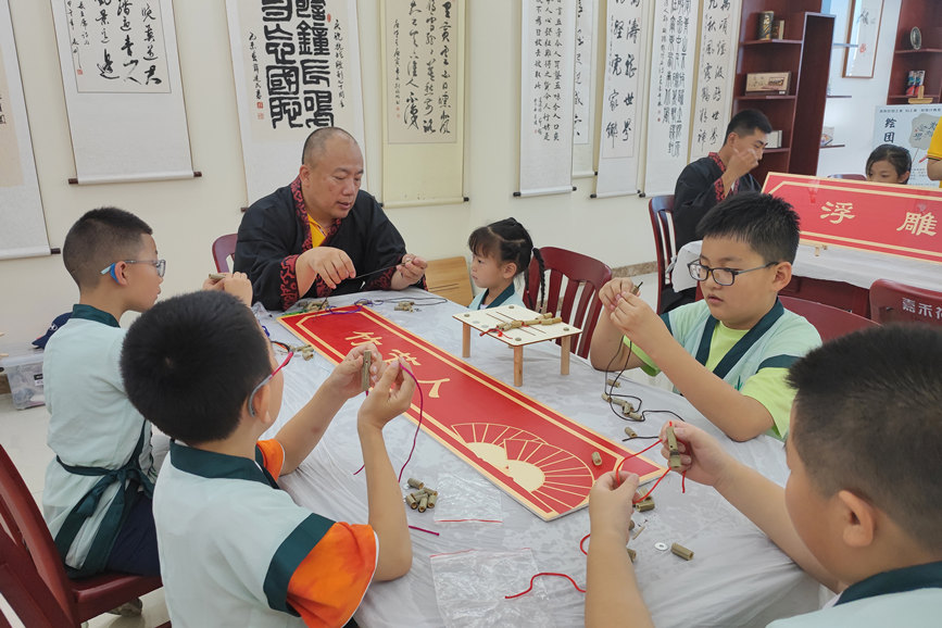 孩子們體驗非遺項目“竹節人”的制作過程。 趙琳英攝