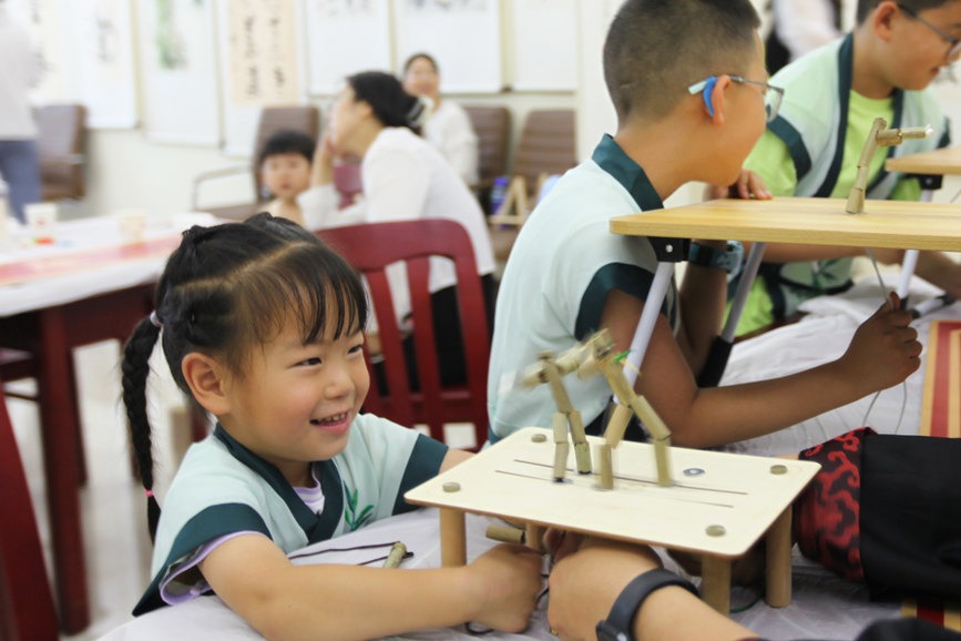 孩子們用“竹節人”“對戰”。趙琳英攝