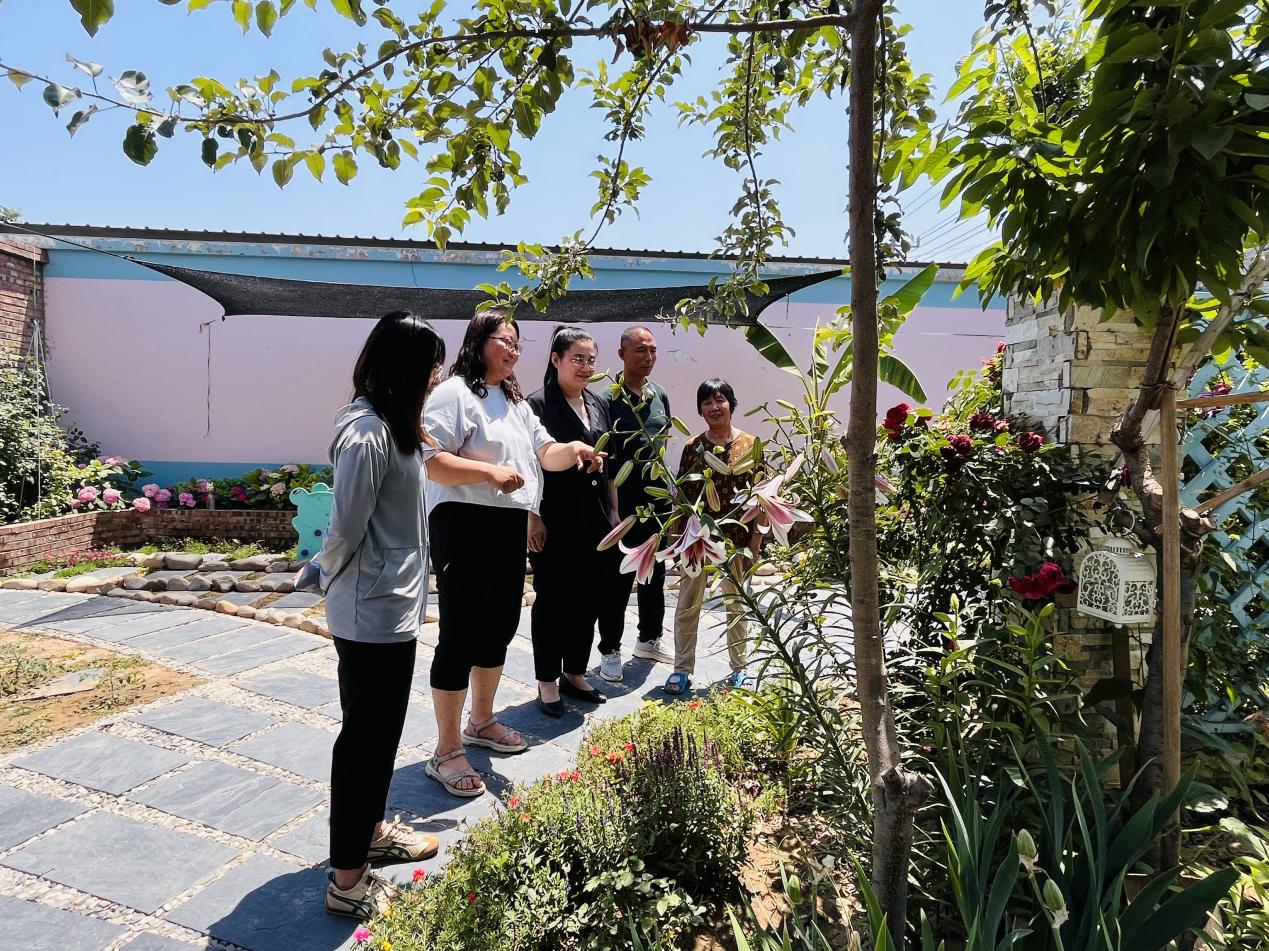 村民正在参观美丽庭院示范户的小院。 李金璐摄