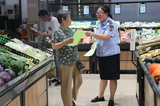 执法人员发放食品安全宣传页。 张甜甜摄