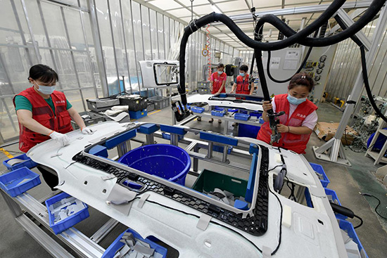 文安県工業新区の自動車部品企業で、労働者が自動車の屋根ライニングを加工している。高丹玉撮影