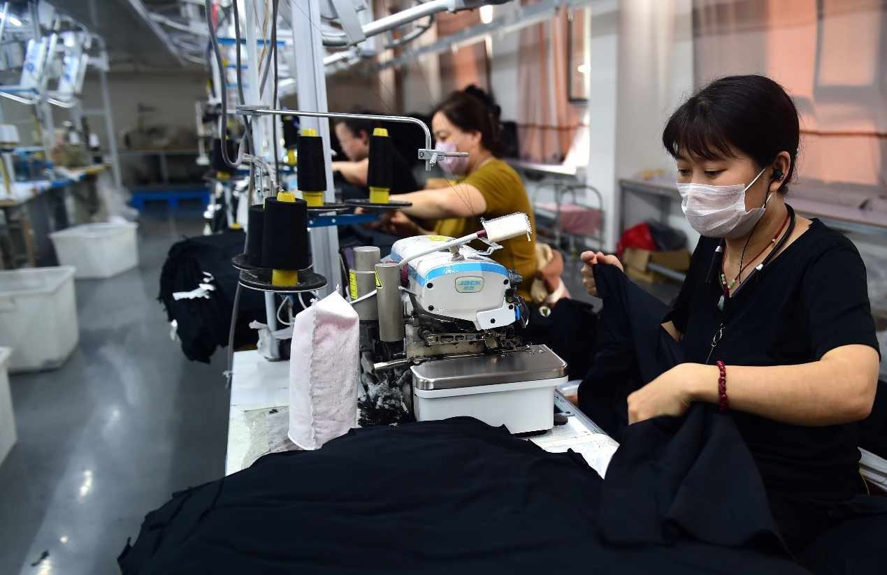 一家服装企业的工人在新落成的生产车间缝制衣服。 傅新春摄