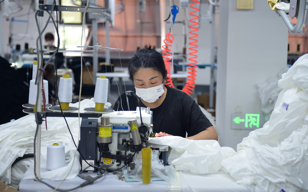 一家服装企业的工人使用新设备缝制衣服。 傅新春摄
