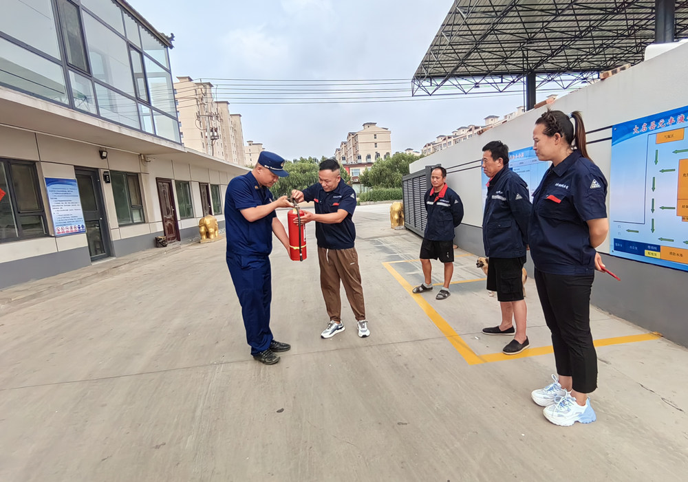 宣讲员走进企业向职工演示灭火器使用方法。 谷聪聪摄