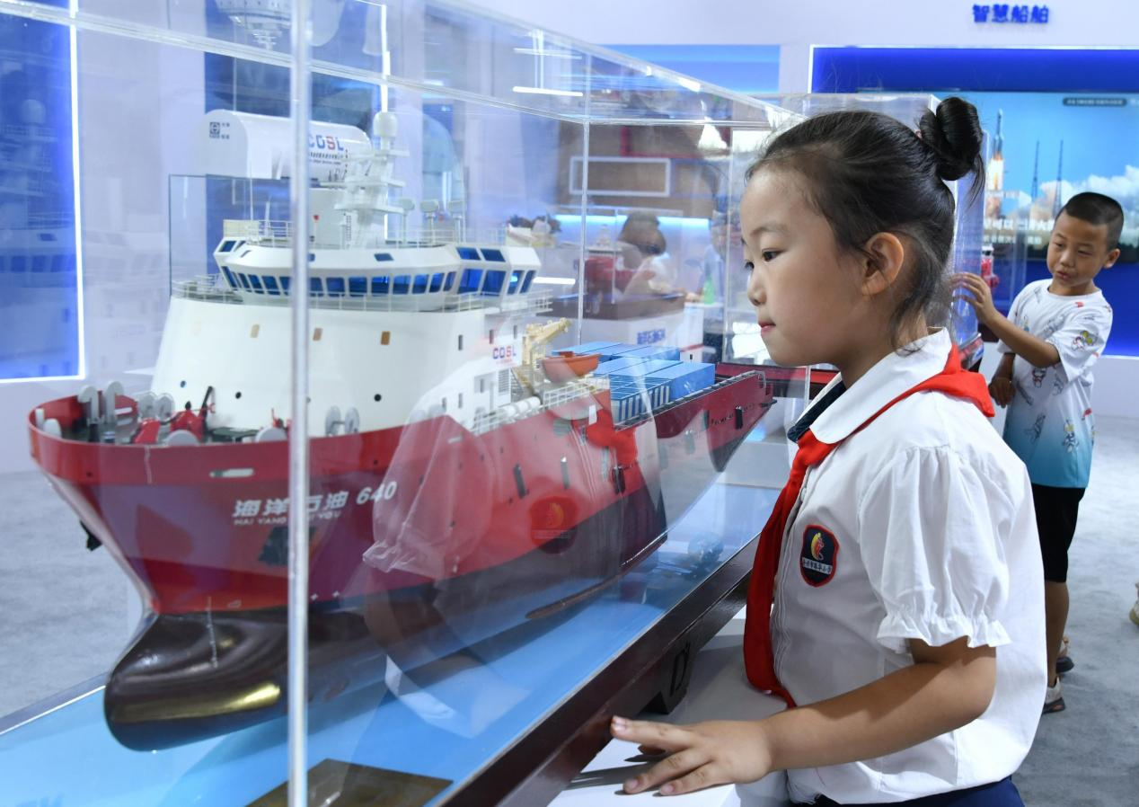 7月11日，小学生在航海科技博览会上参观轮船模型。 苑立伟摄