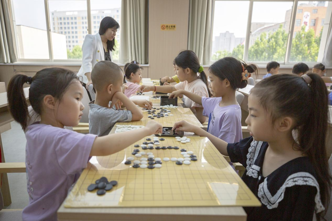 在河北省唐山市丰南区爱心暑托班围棋课上，孩子们在老师的指导下学习围棋。 翟子阳摄