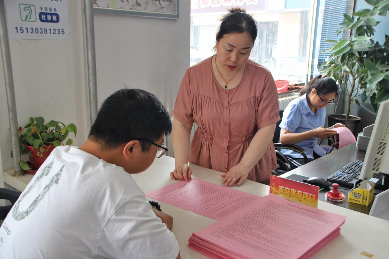 县残联工作人员宣传残疾人两项补贴优惠政策。 张光伟摄