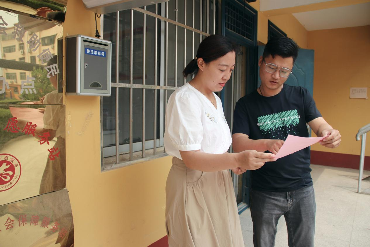 社区工作人员向群众解读残疾补贴“跨省通办”业务办理政策。 张光伟摄