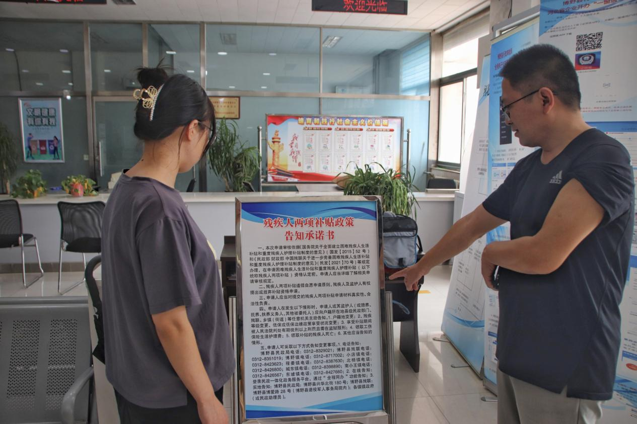 县民政局工作人员向群众宣读残疾人两项补贴告知承诺书。 张光伟摄