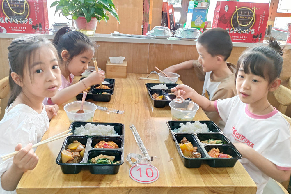 孩子们在暑期托管班享受午餐服务。 孙志敏摄