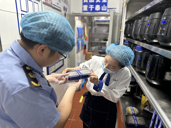 桥西区市场监管局工作人员指导餐饮企业规范使用食安封签。 翟志华摄