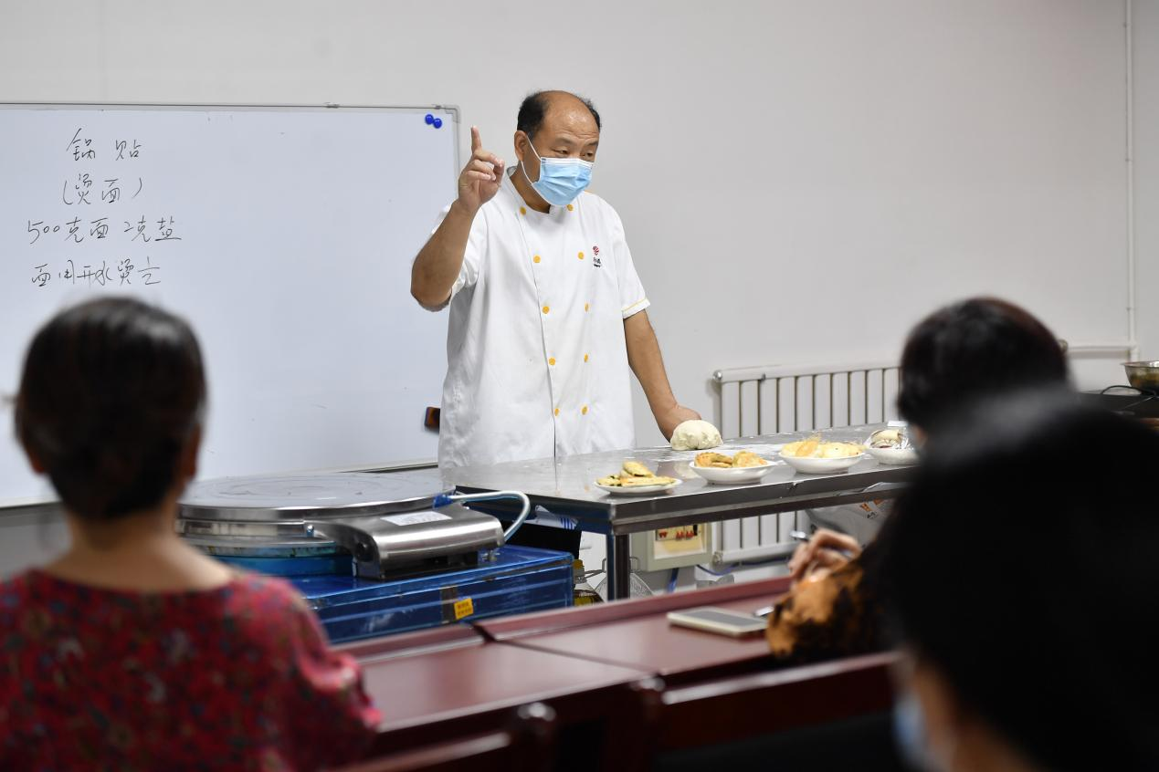 在文安县一家培训学校中式面点免费培训班，面点师为学员讲解制作流程。 王晖摄