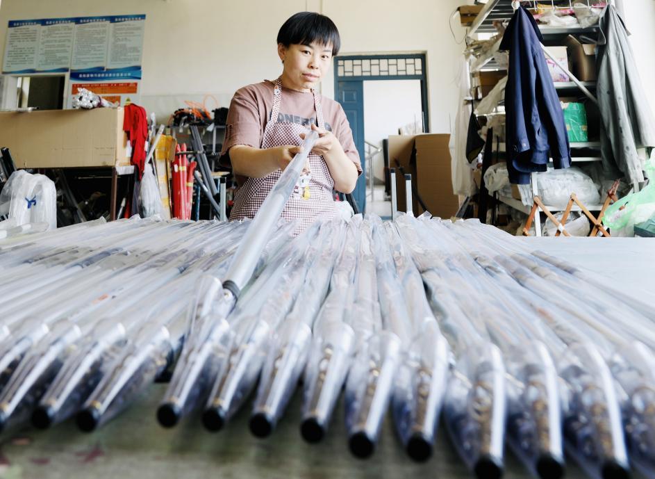 肅寧縣河北留善寺鎮一漁具企業車間，工人在給魚竿套上包裝袋。 劉巨雷攝