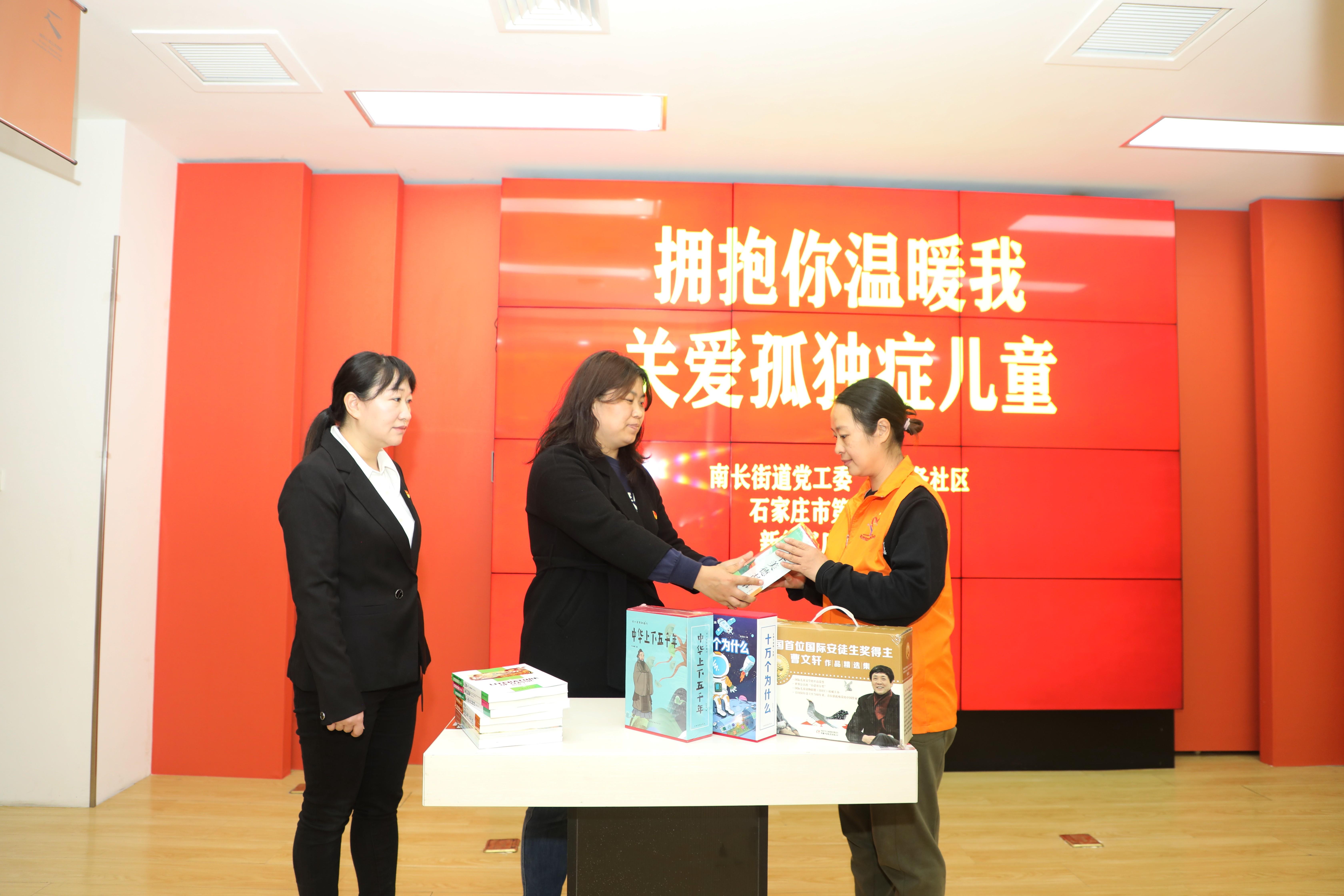 南长街道工作人员在“融趣集·八度”书屋向社区红色社会组织孤独症喘息站捐赠儿童读物。 董璐摄