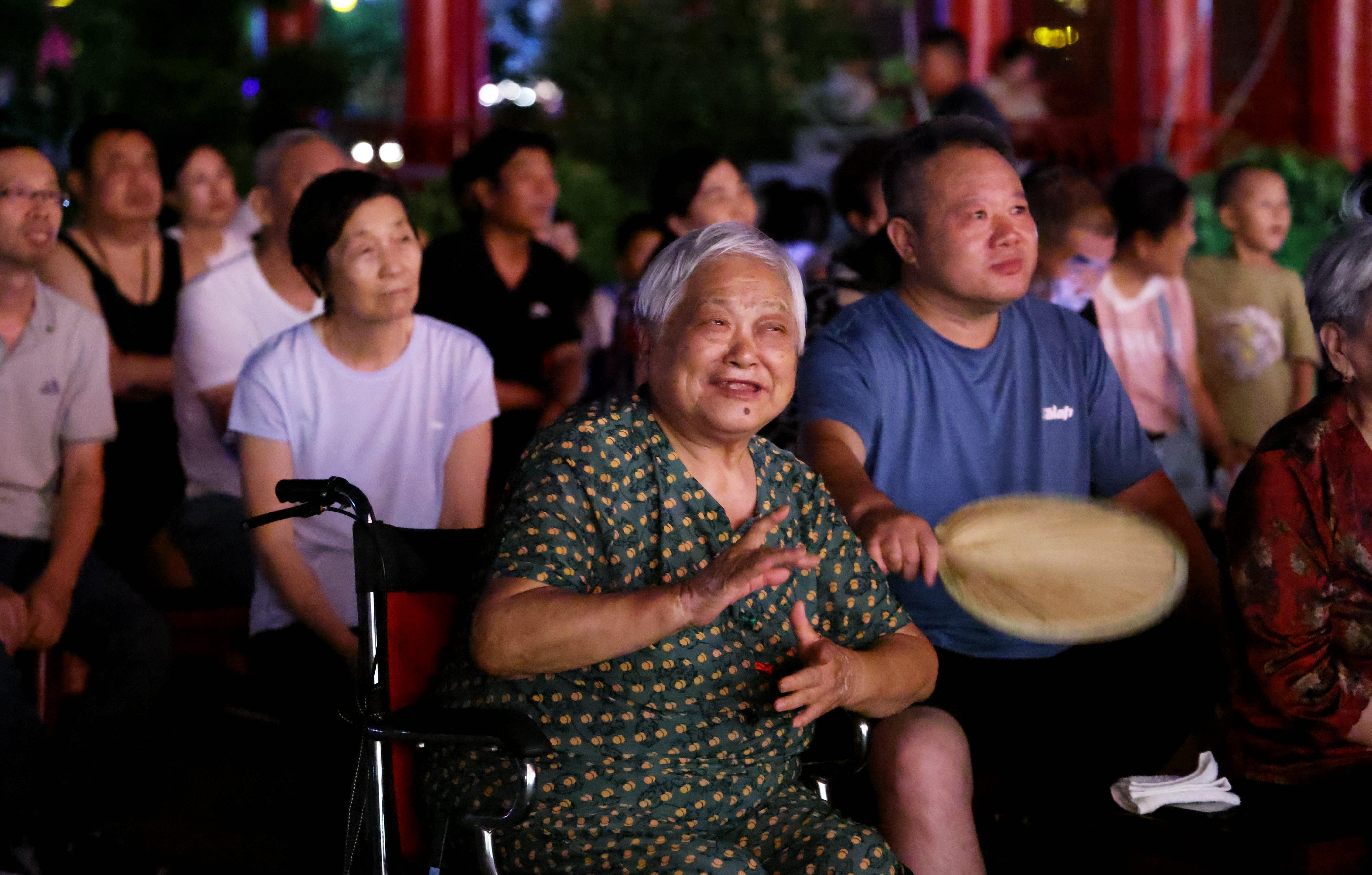 戏曲爱好者在沧州市南川楼下听着悠扬的曲调沉浸其中。 王杰摄