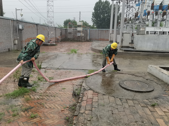 7月30日，廊坊永清公司变电运维班王永增，姜玉普在城南35千伏变电站的低洼处进行排水。穆建军摄