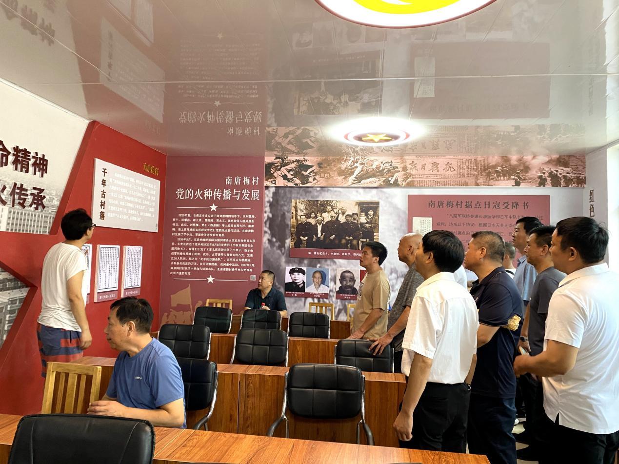 南唐梅村委会委员陈芳刚为退役军人讲解展厅模块内容。 张梦璇摄