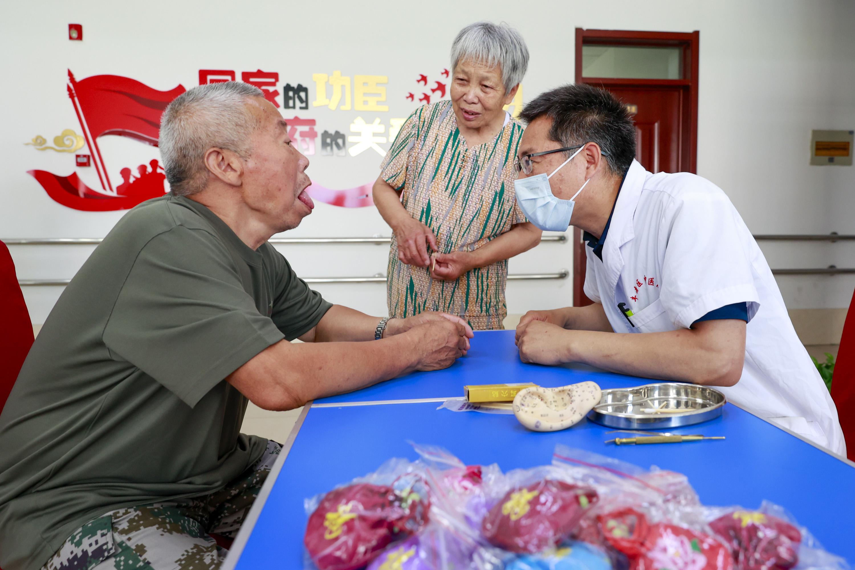 河北省唐山市丰南区中医医院医务人员为光荣院的老人进行中医诊治。 孟东红摄