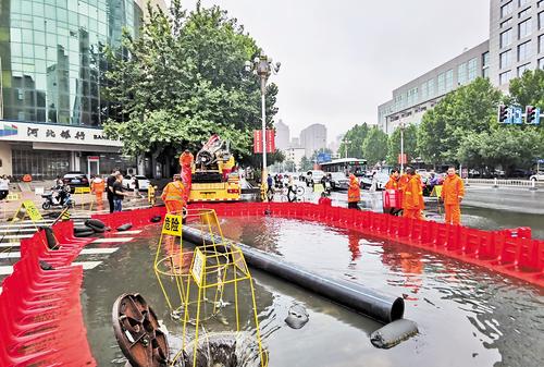 7月31日，石家庄市裕华路与南小街交口处，工人正在清除积水。河北日报记者 张 昊摄