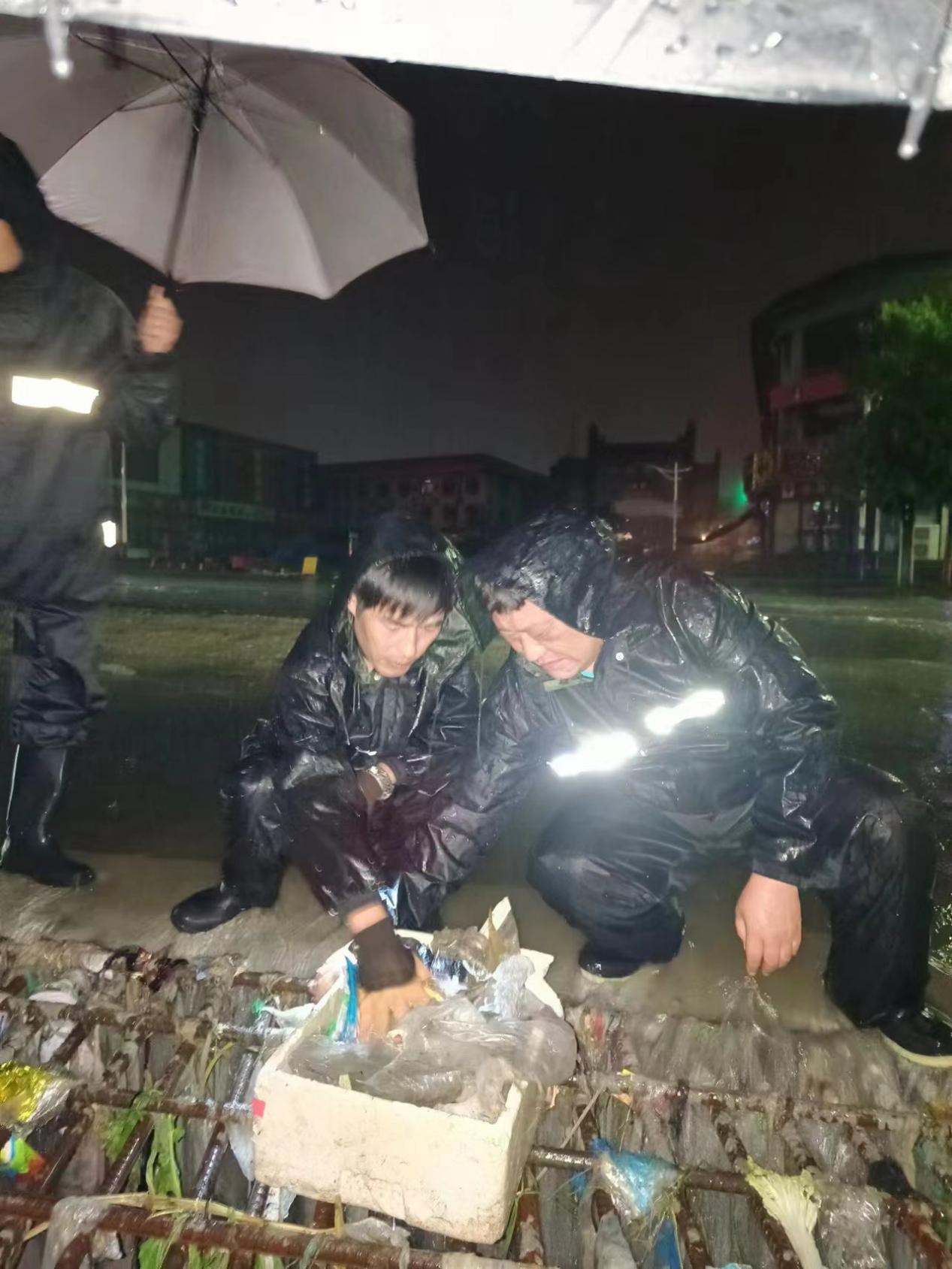 执法局工作人员正在清理下水口，确保排水系统畅通。 涞源县委宣传部供图
