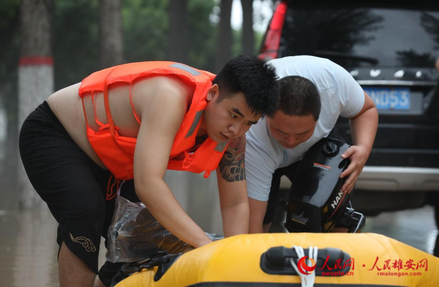 8月1日傍晚，救援人员正在带着冲锋舟奔向涿州市刁窝镇受灾村庄。 人民网 李兆民摄