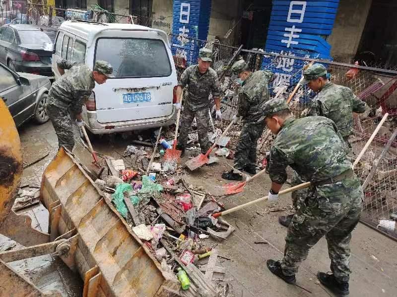 8月5日早上，武警保定支队派出70余名官兵沿涿州107国道方向对道路两旁的淤泥垃圾进行清理。 郑泽楠、梁学峰摄