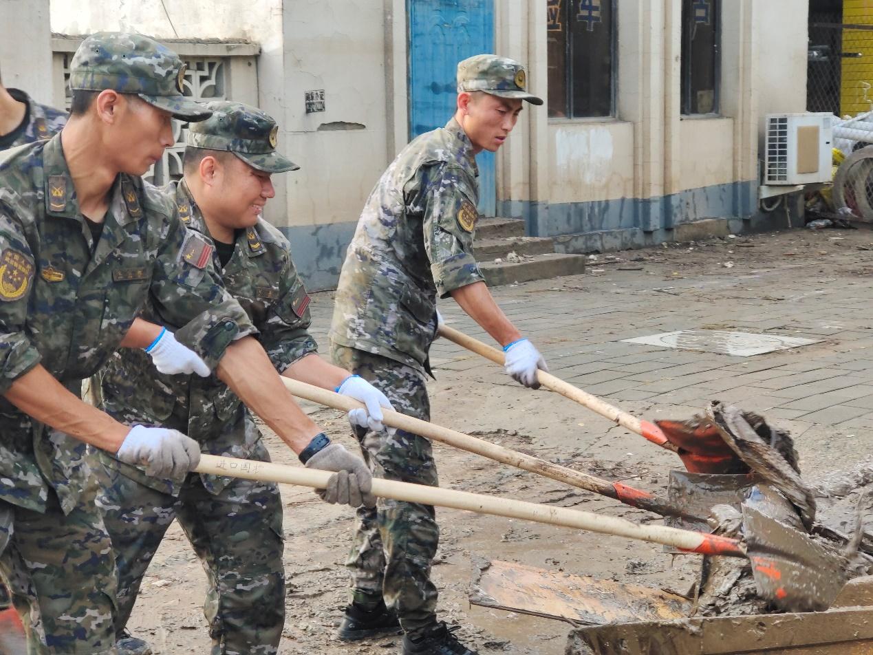 8月5日早上，武警保定支队派出70余官兵力沿涿州107国道方向对道路两旁的淤泥垃圾进行清理。郑泽楠、梁学峰摄