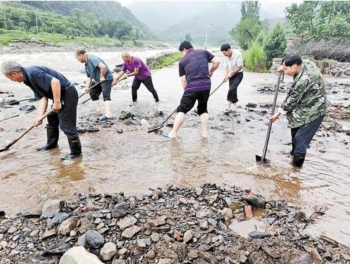 洪峰过后，村民们合力清理路面。 河北日报通讯员 曹春江摄