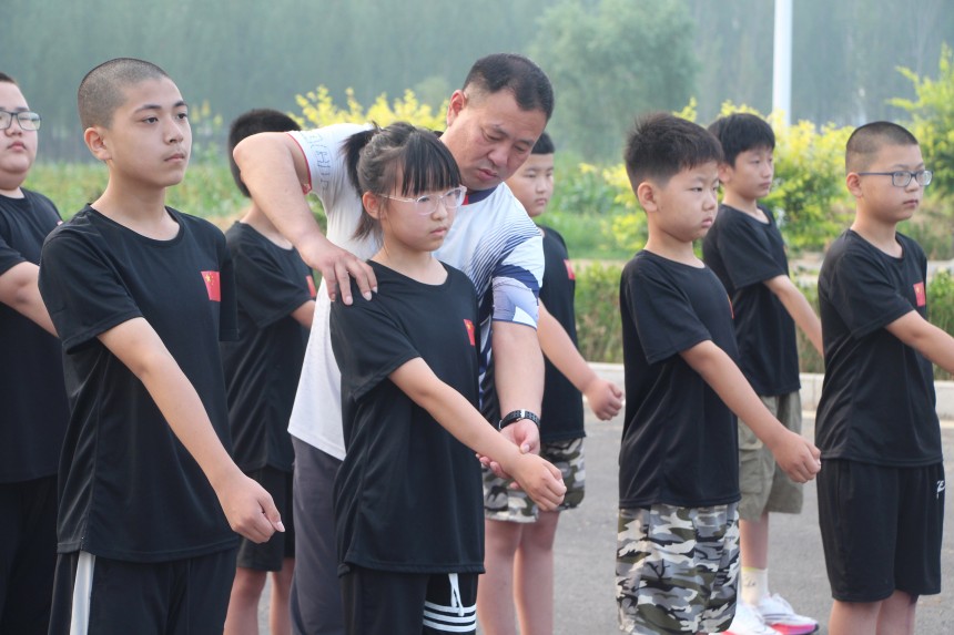 教练手把手教孩子摆臂动作要领。 芦建勇摄