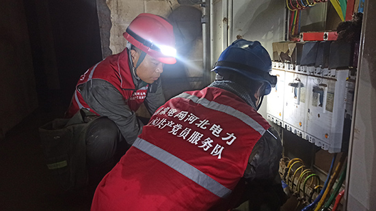 8月6日，国网景县供电公司援涿党员突击队在地下一层配电室抢修因洪水冲刷受损的配电柜。 冯钊摄
