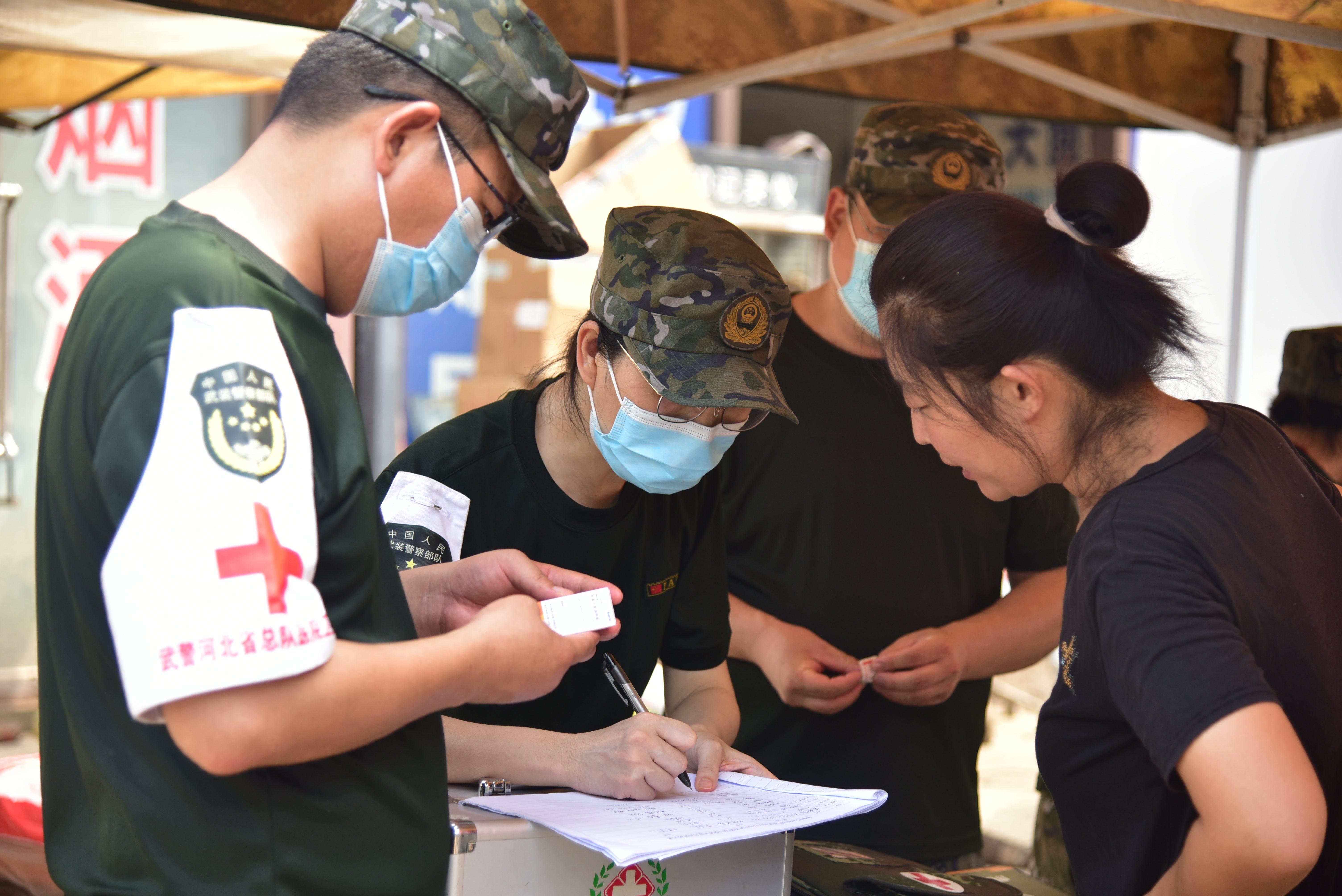 8月9日，武警河北总队医院医疗分队在河北涿州大石桥农产品批发市场附近开设便民医疗点，为群众提供诊疗服务。 杨雪乾摄