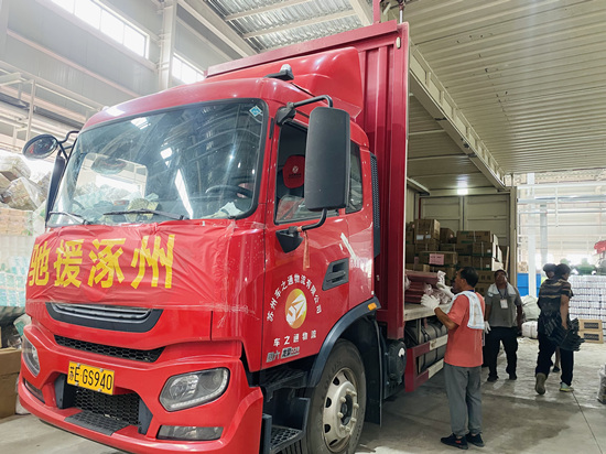 工作人員和志願者在涿州市鋼研物資儲備點忙著卸車。班靜怡攝