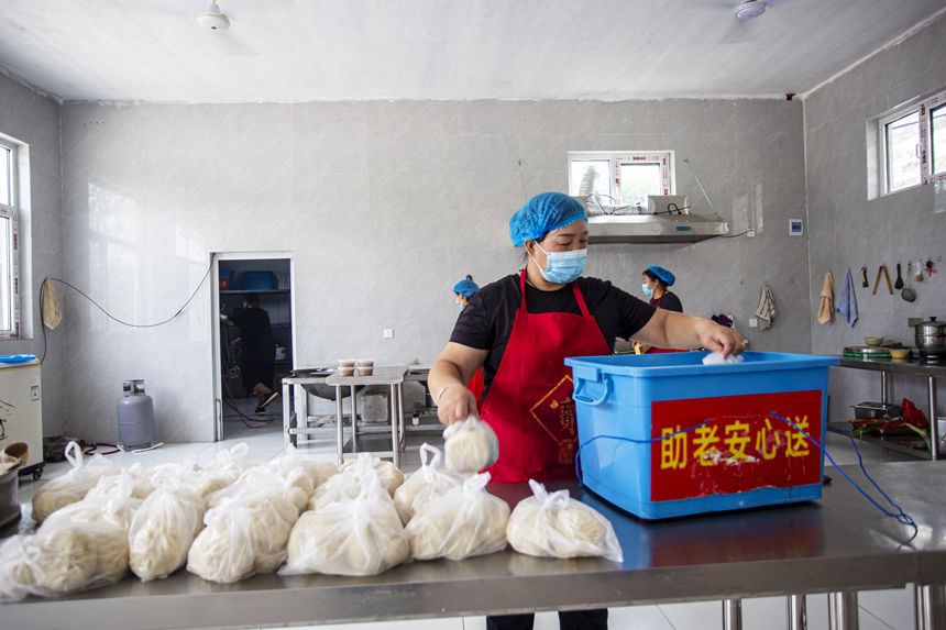 日前，在河北省邯鄲市復興區戶村鎮戶村村助老愛心餐廳，工作人員將大包子裝袋准備配送。 聶長青攝
