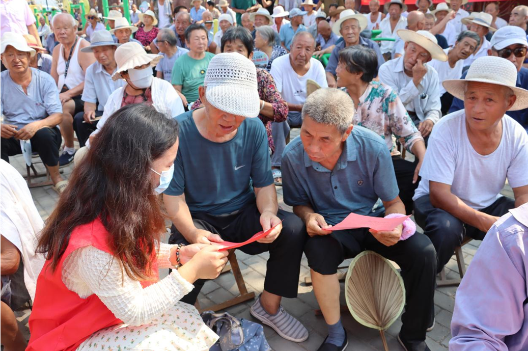 文明志愿者在为群众宣传理论政策。 石新冰摄