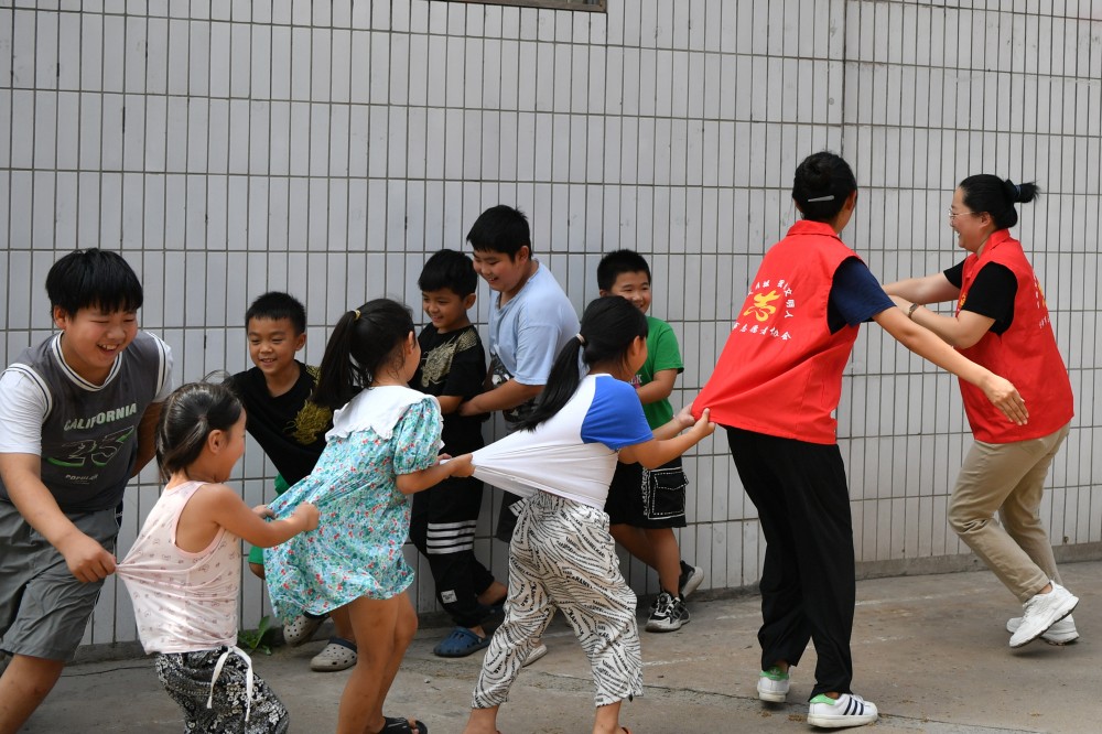 8月10日,在迁安市沙河驿镇唐庄子村党群服务中心内,志愿者陪村内儿童做游戏。 彭月娟摄