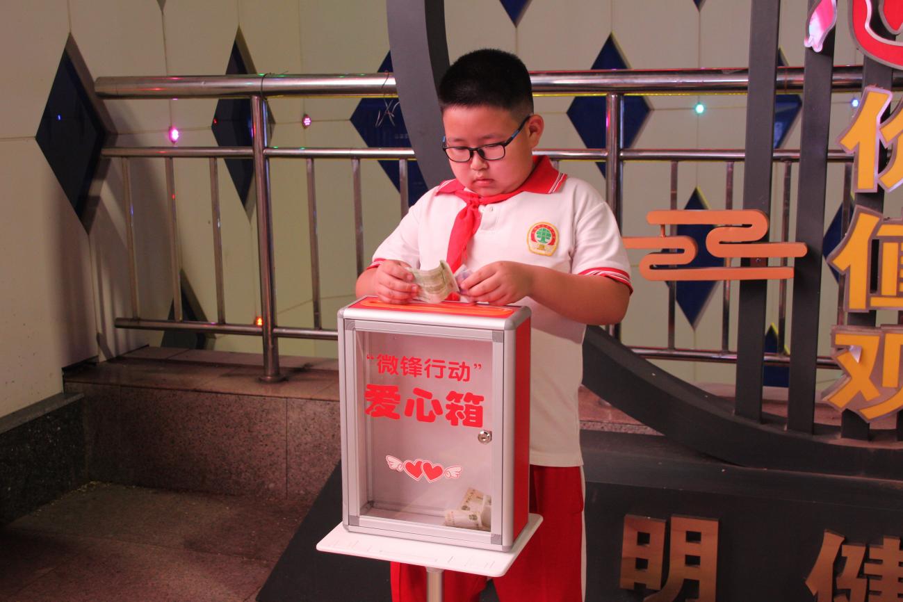 孩子們將義賣收入放入愛心箱。 蕭子惠攝