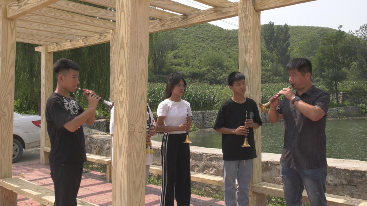 老师传授吹歌演奏技巧。 王航摄 