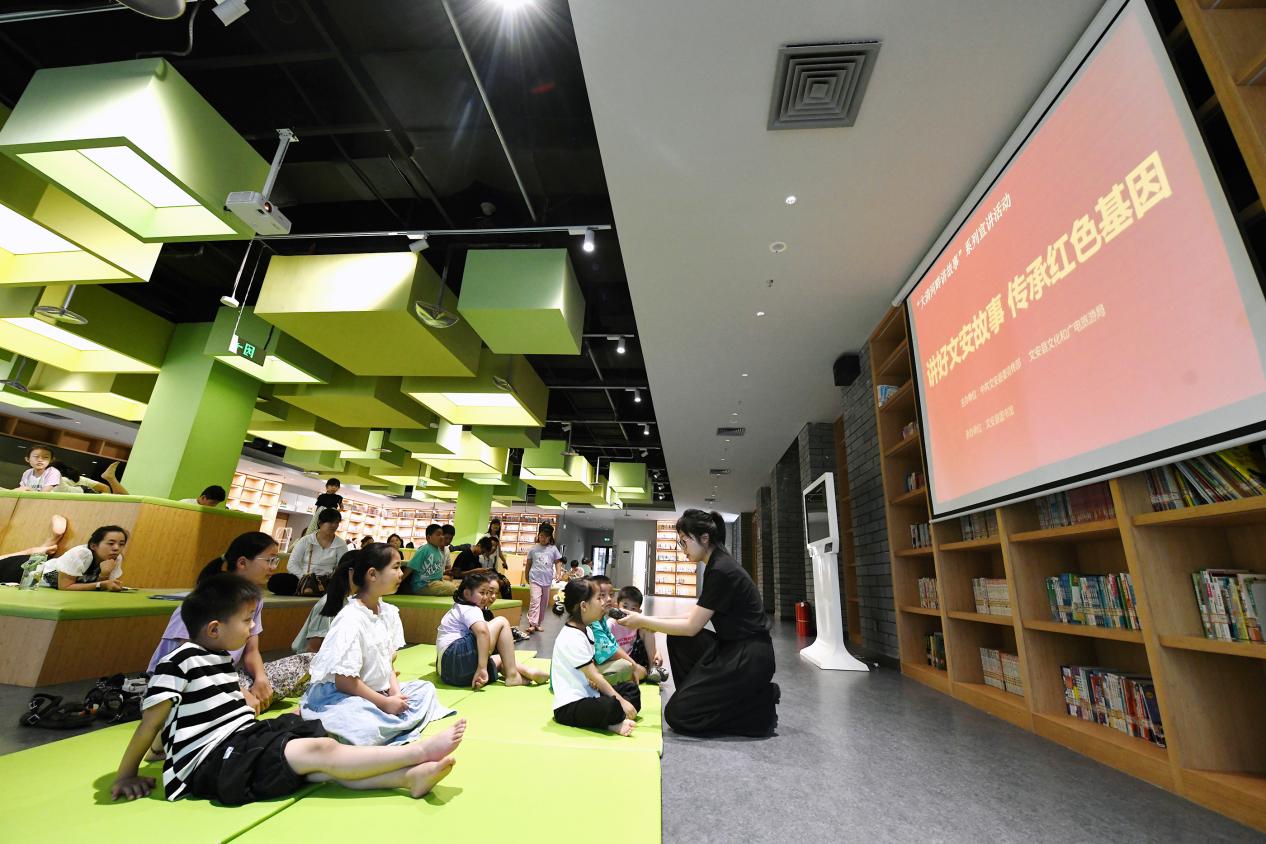 文安县文化艺术中心图书馆，志愿者和小朋友互动。 高丹钰摄
