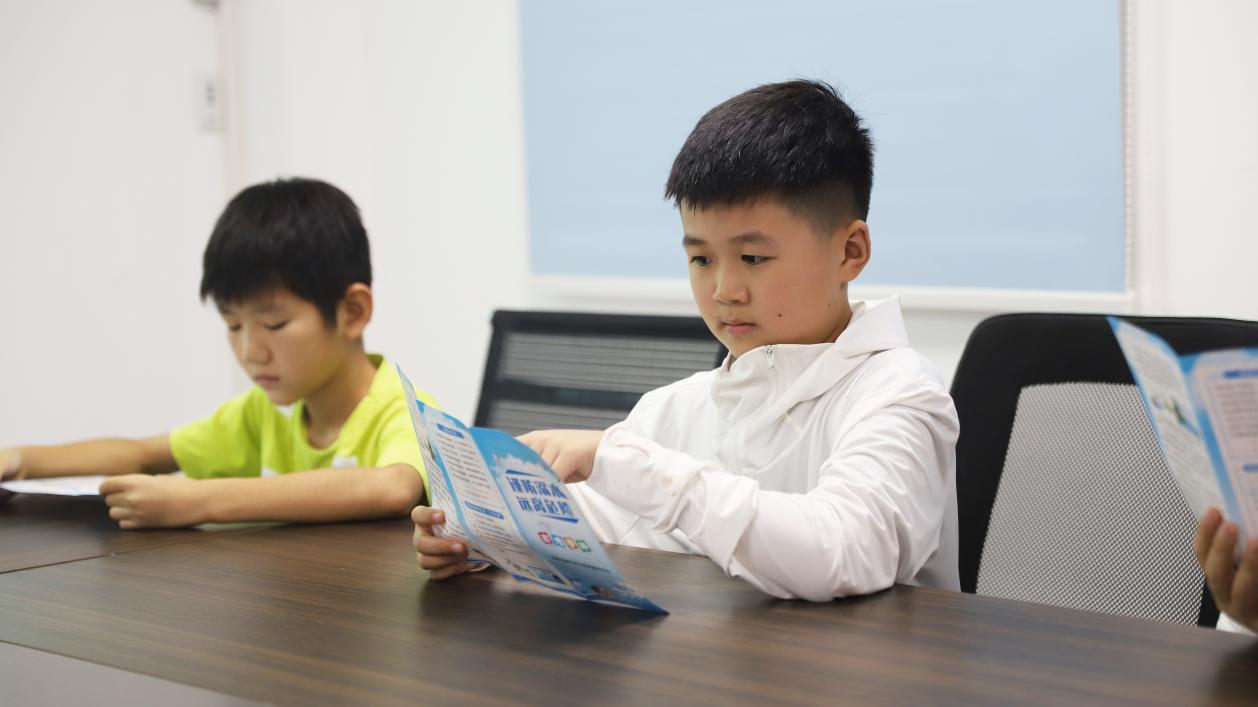 孩子們認真閱讀防溺水安全手冊。 喬春恆攝  