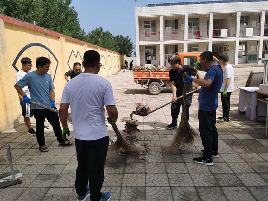 在河北省高碑店市新城镇新城中学的校园内，教职员工正在清理卫生。 李惠林摄