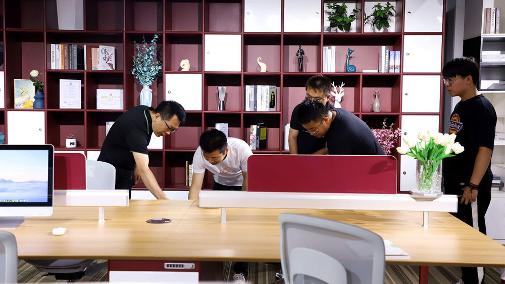 工作人員向顧客介紹辦公家具的細節。 朱鈺爽攝