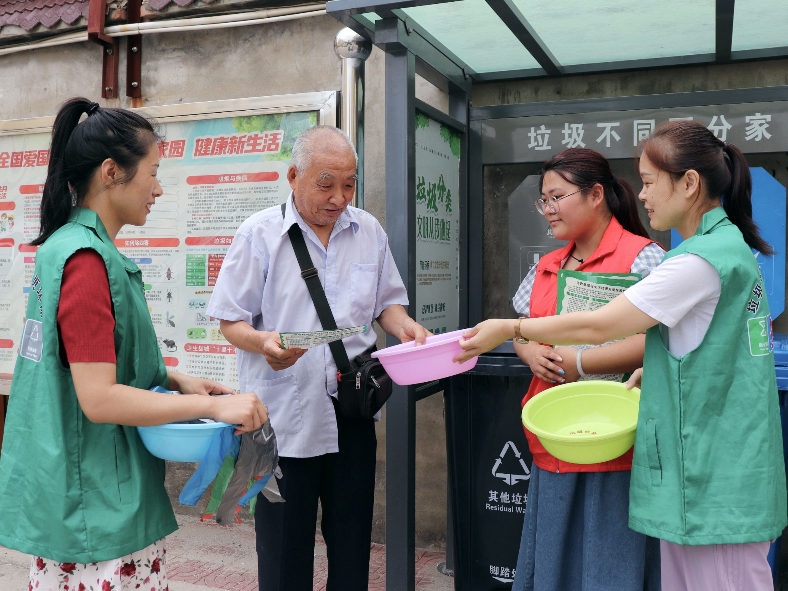 志愿者给居民发放活动礼品。 张光伟摄