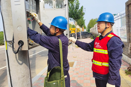 國網晉州市供電公司服務人員為新建晉州市第八小學裝表接電。 彭磊攝