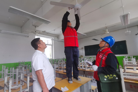国网赵县供电公司党员服务队队员在赵县中学检查用电设施。 侯西果摄