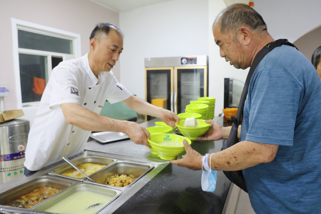 在石家庄市桥西区中山街道长者助餐厅，老人正在打饭。 董璐摄