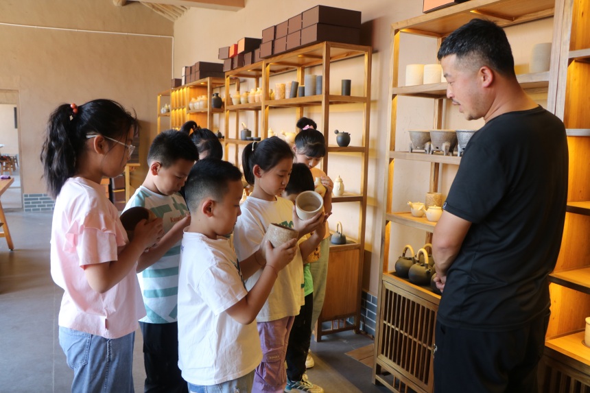 青少年们在河北省蔚县南留庄镇白河东村青砂器生产基地参观体验青砂文化 。 蔺媛媛摄
