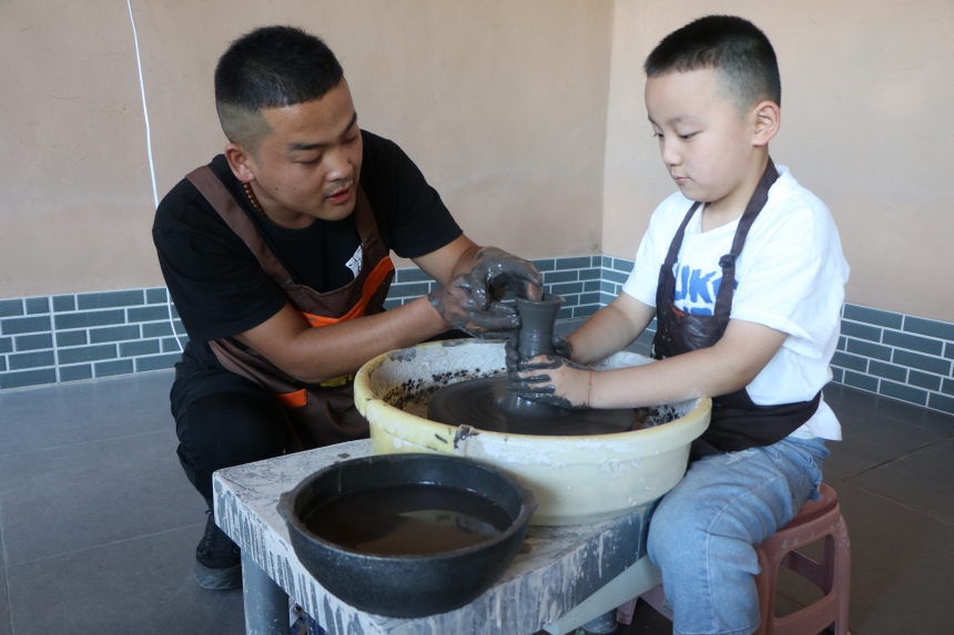青少年们在河北省蔚县南留庄镇白河东村青砂器生产基地参观体验青砂文化 。 蔺媛媛摄