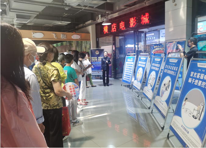 民警利用展板向居民進行電信詐騙防范知識普及。 張宇攝