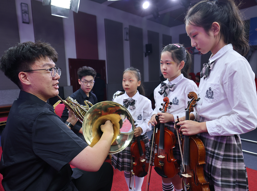 乐团演奏人员为孩子们现场讲解管乐乐器。 樊青芳摄